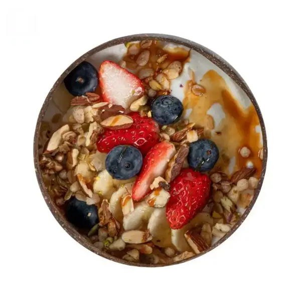 Coconut Shell Breakfast Bowl Top View Top view of a coconut shell bowl filled with yogurt, granola, strawberries, blueberries and banana
