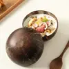 Natural Coconut Shell Bowl Halves Two natural coconut shell halves with one used as a bowl for yogurt, fruit and granola