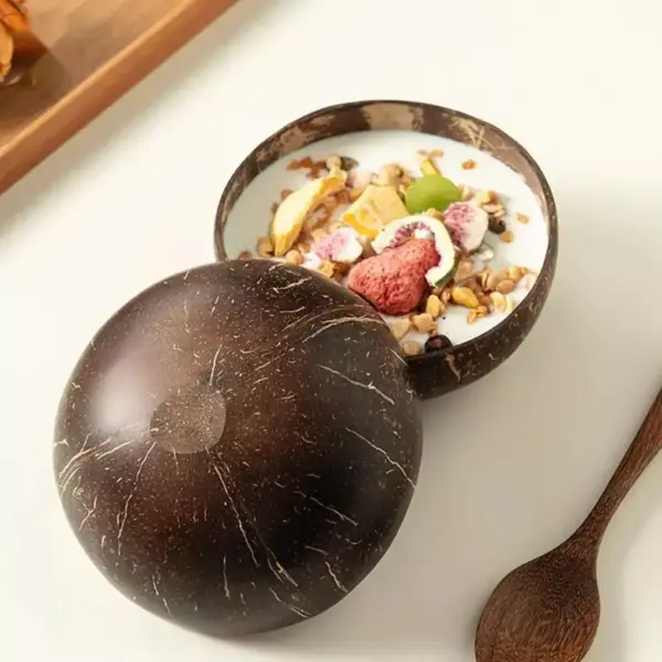Natural Coconut Shell Bowl Halves Two natural coconut shell halves with one used as a bowl for yogurt, fruit and granola